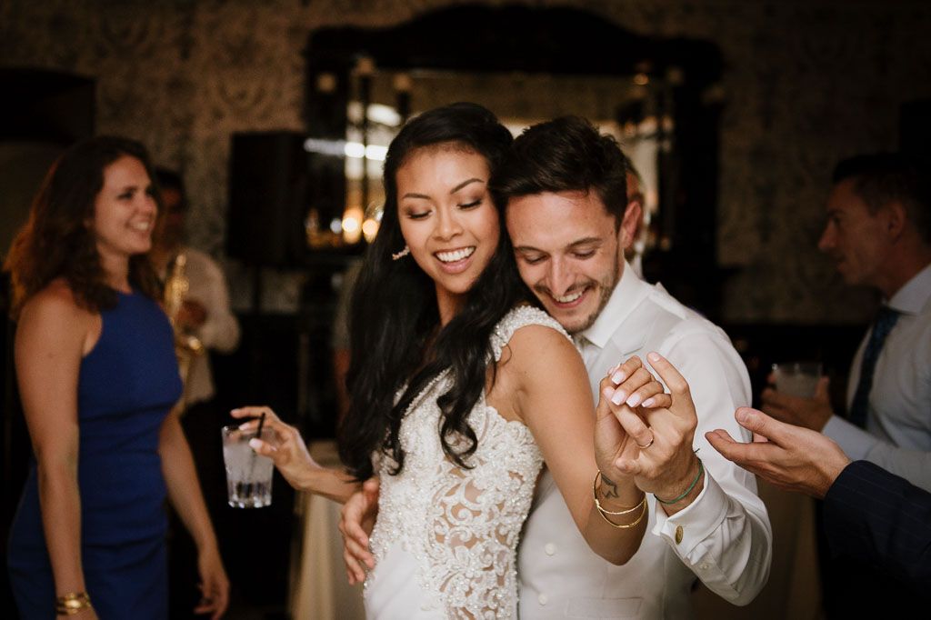 Wedding guests enjoy a candid moment together during an evening reception celebration.