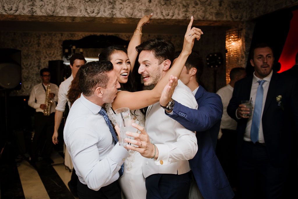 Wedding guests dancing together in a ballroom during a celebratory reception.