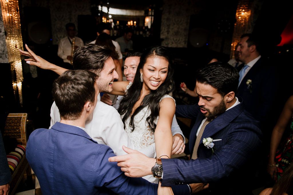Wedding guests celebrate and dance together during a lively reception party moment.