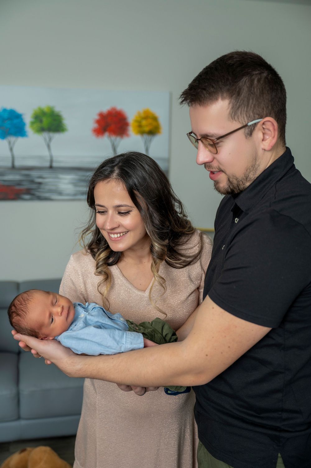 Parents share tender moments with their newborn baby in a series of loving family portraits at home.