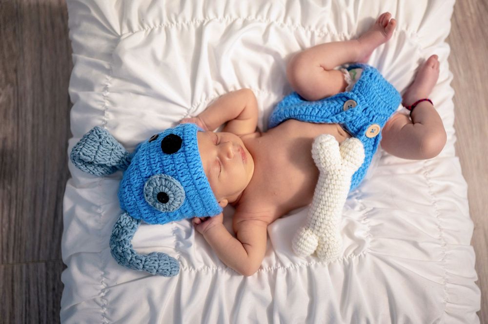 A series of photos showing a crocheted baby bootie being made in blue and white yarn on white fabric.
