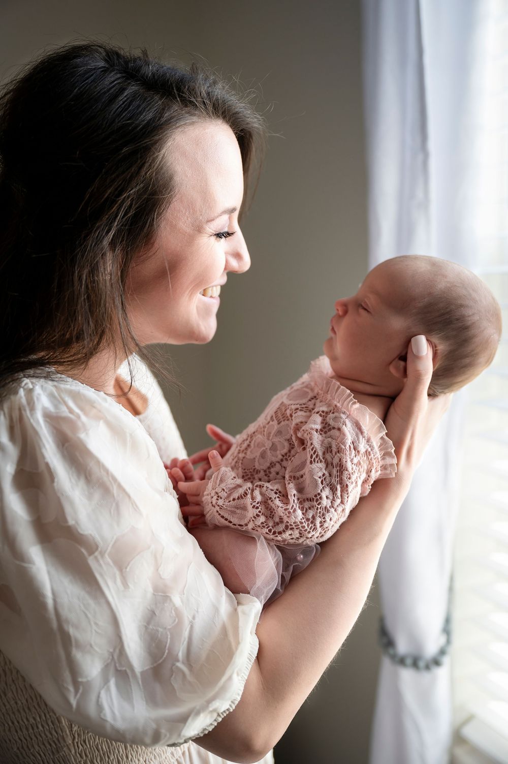 A series of intimate portraits showing tender moments between parent and newborn in soft natural light.