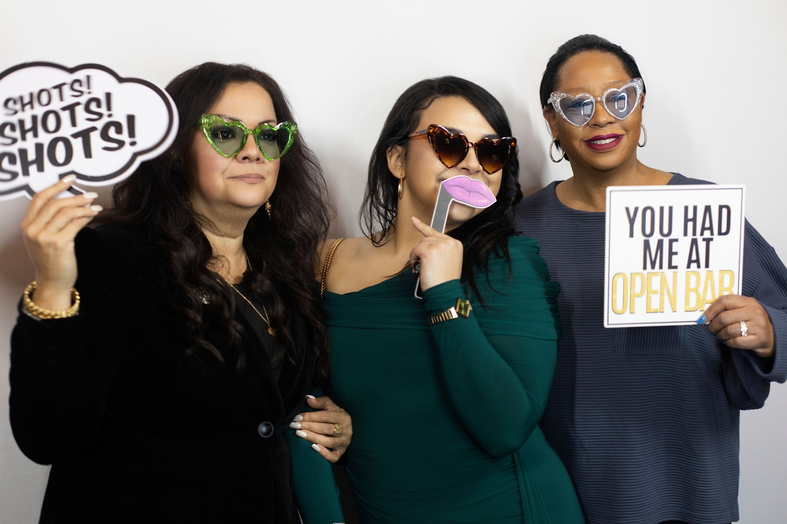 Group photo series showing people in dark green tops posing with fun signs.