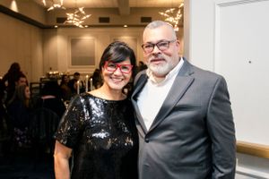 Group photo at formal event with people wearing suits and sparkly dresses.