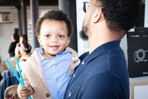 Parent and child share a joyful moment together at an event.