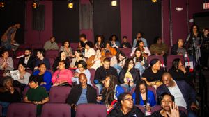 Large audience seated in theater-style seating at an indoor event.