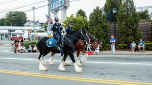 View of a street parade with spectators lining the sidewalks.