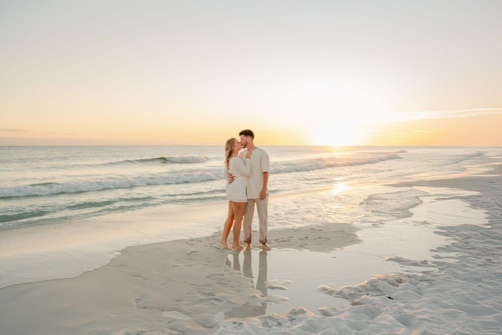 A couple embracing on the shoreline during golden hour at the beach.