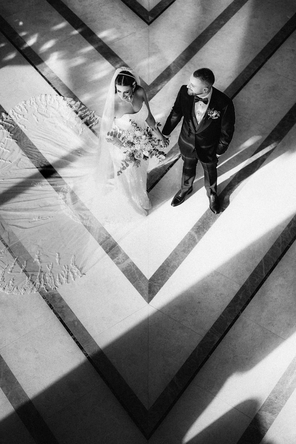 Black and white artistic series showing shadows and footprints in snow creating geometric patterns and movement.