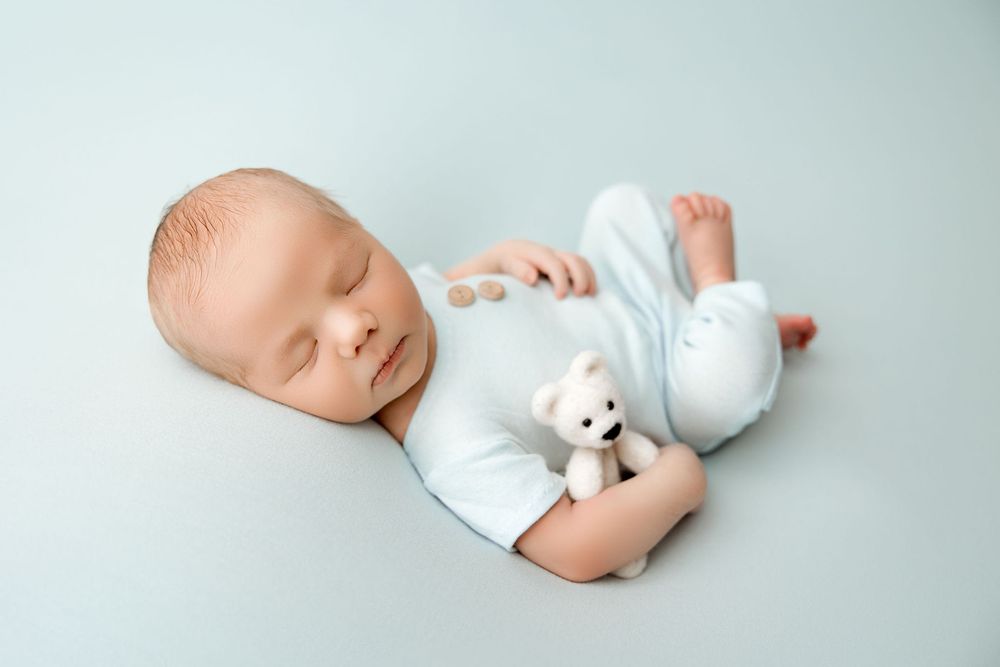 Newborn baby boy picture in a light baby blue set up. Chicago area Newborn photography