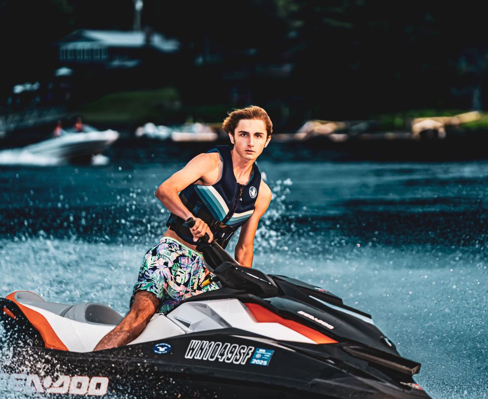 Dynamic water sports photograph of orange jet ski spraying water.