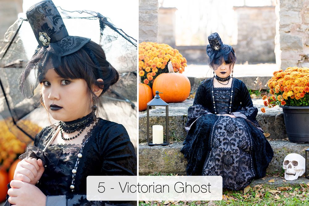 Child in a Victorian ghost Halloween costume with a black lace dress and mini top hat posing by pumpkins, mums and a skull.
