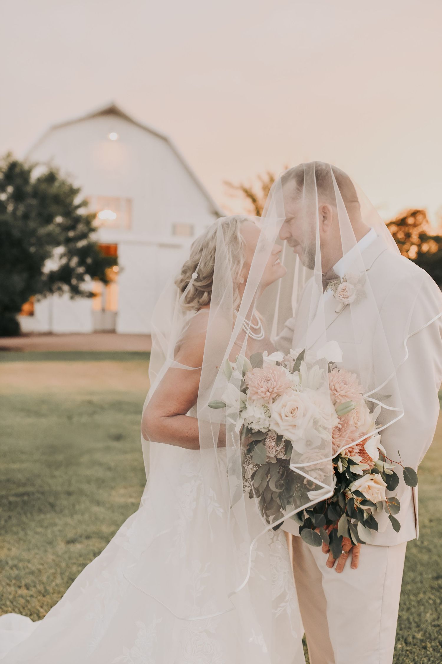 Romantic wedding portrait featuring The White Sparrow white chapel at sunset