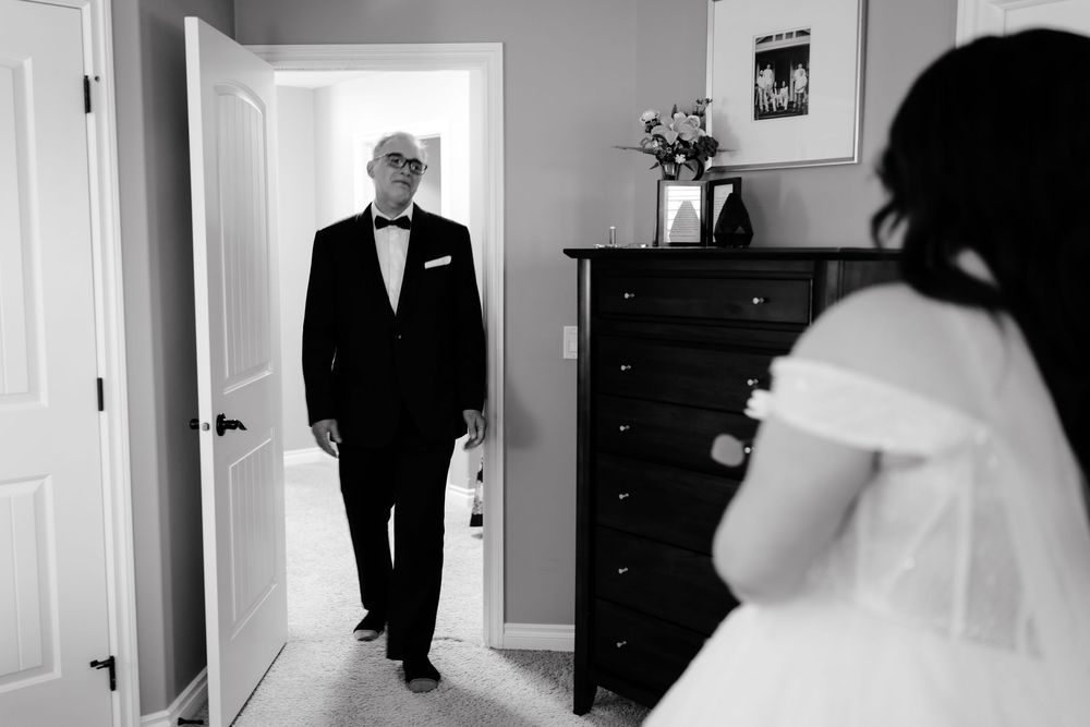 Father sees bride in wedding dress for the first time, an emotional black and white wedding getting ready moment.