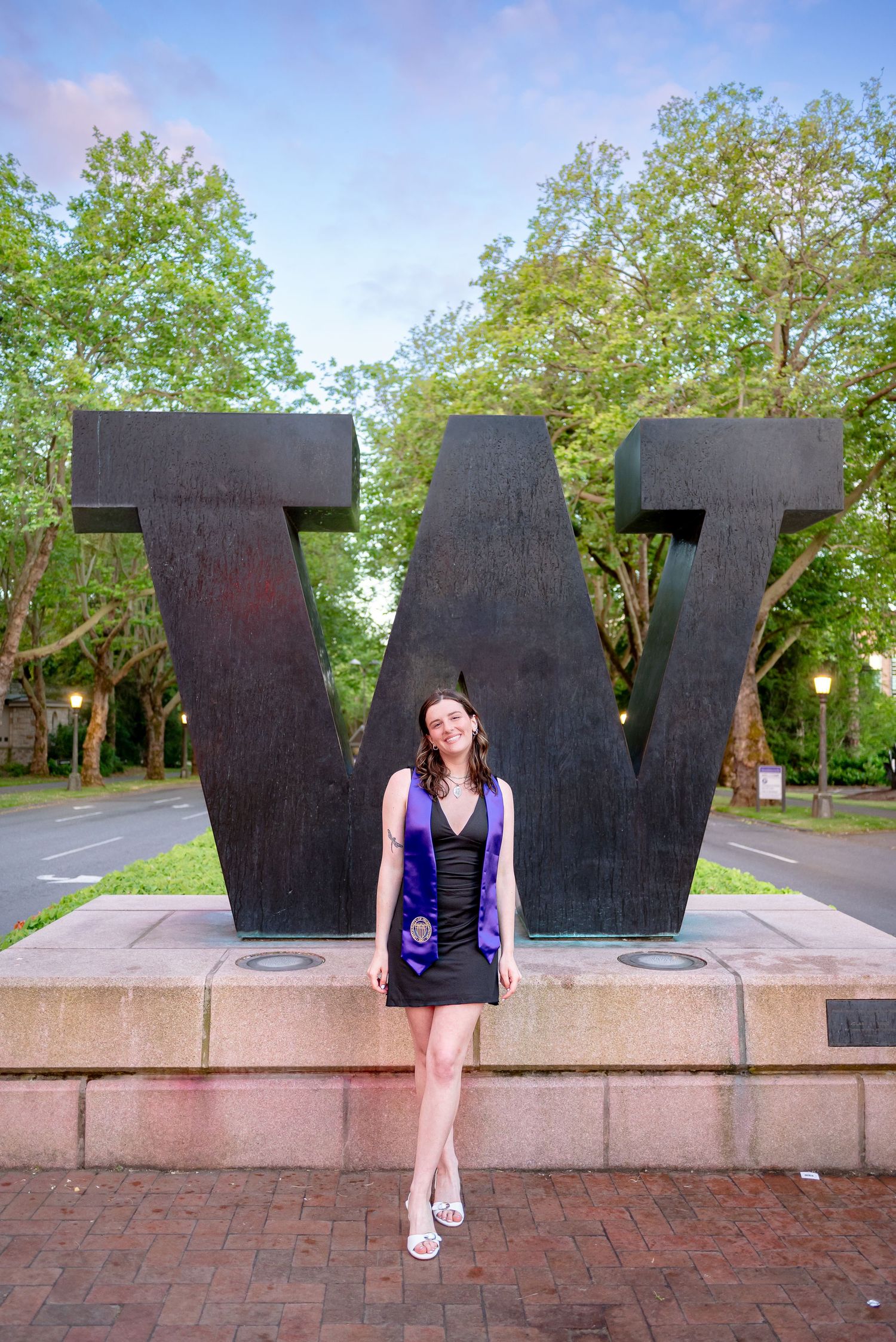 University of Washington graduate posing in front of the W Sculpture on campus