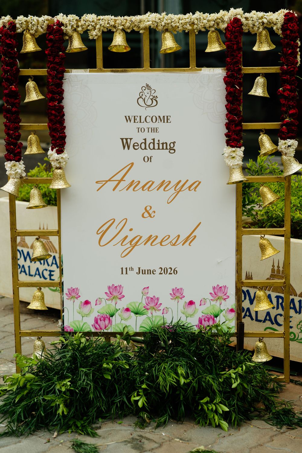 Elegant wedding welcome sign for Ananya and Vignesh dated June 11 2026 decorated with lotus flowers and gold bells.