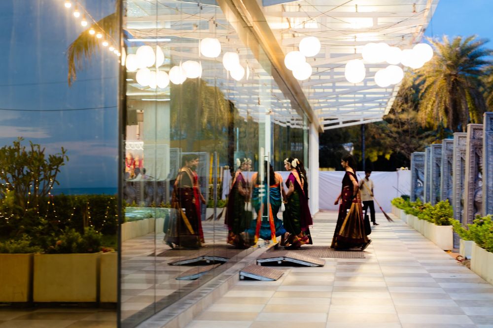 Elegant mannequins displaying traditional Indian attire reflected in glass walls at a modern shopping venue.