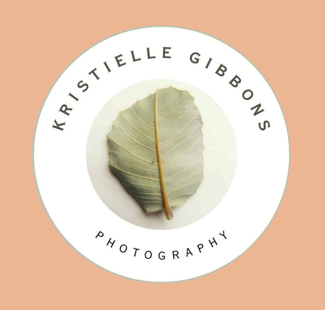 Kristielle Gibbons Photography logo featuring a dried green leaf centered in a white circle on a peach background.