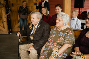 the parents of the bride watching their daughter get married on a rainy fall day