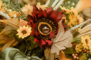 a fall bouquet with two wedding rings in the center