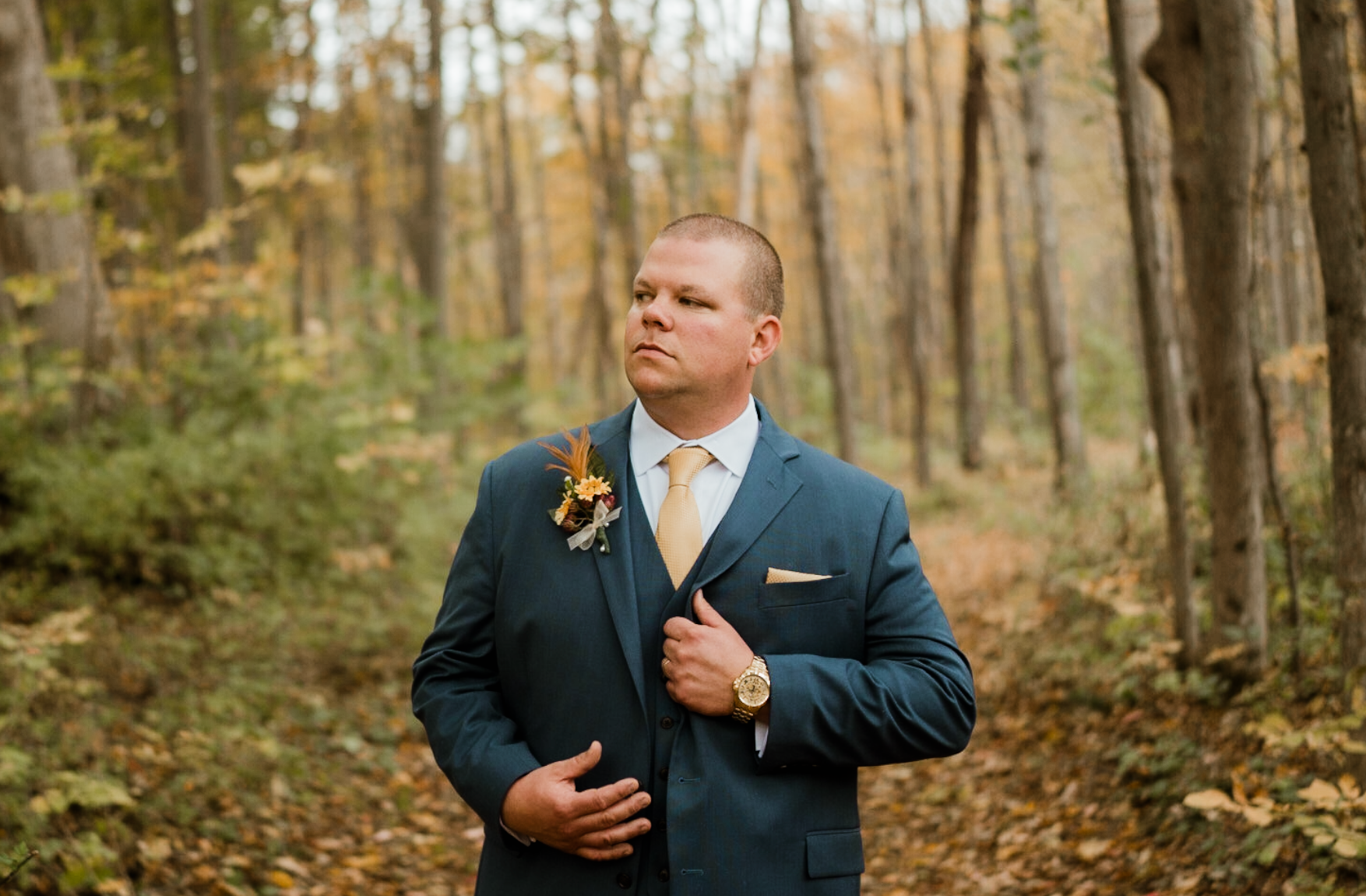 a man in a suit looking stoic during his portrait session of his wedding day