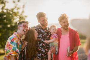 a lovely family and friends photo of a queer couple on their wedding day