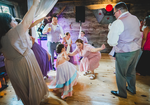 family and friends dancing in a wedding venue having a wonderful time