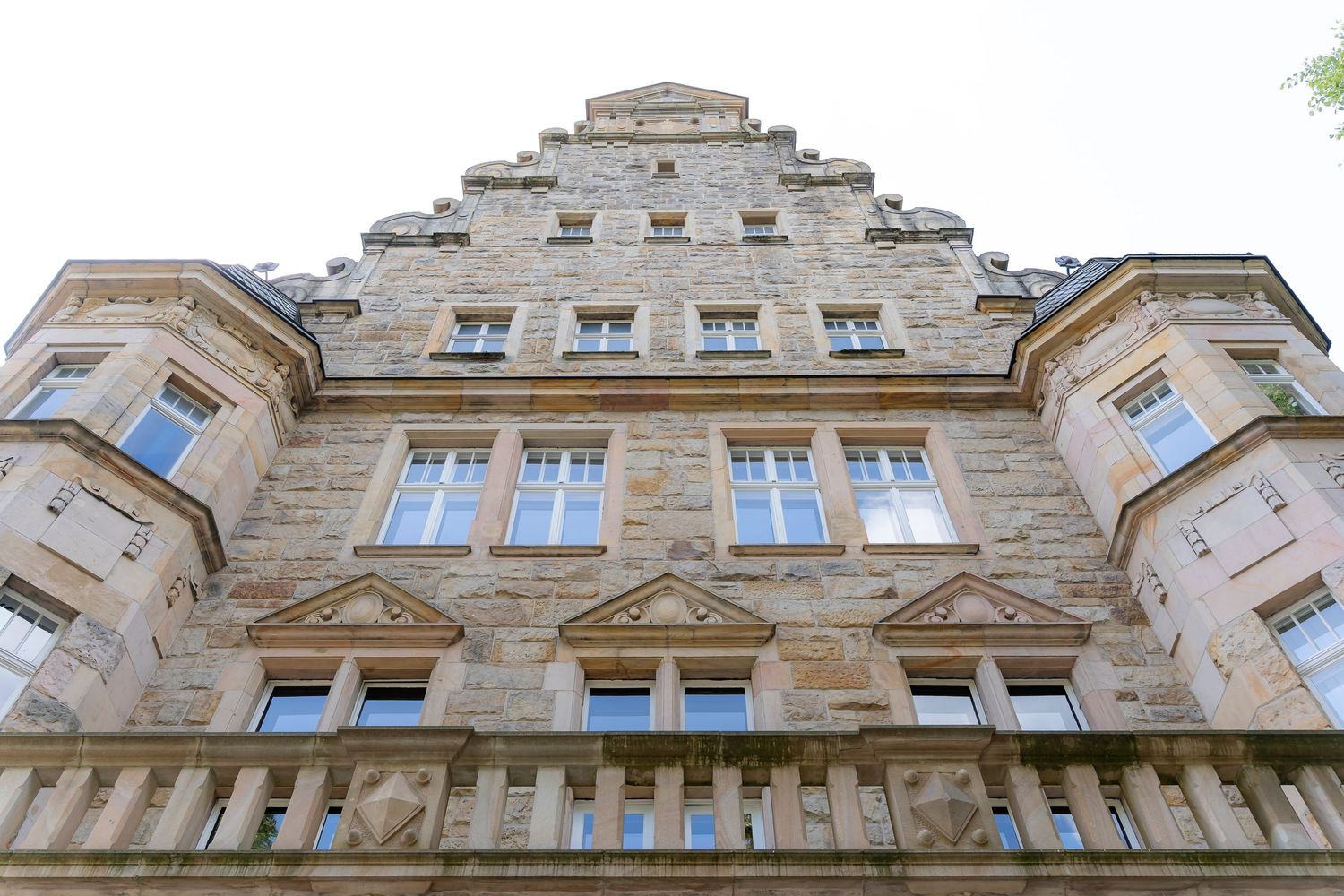Low angle view of historic stone building facade with ornate stepped gable architecture.