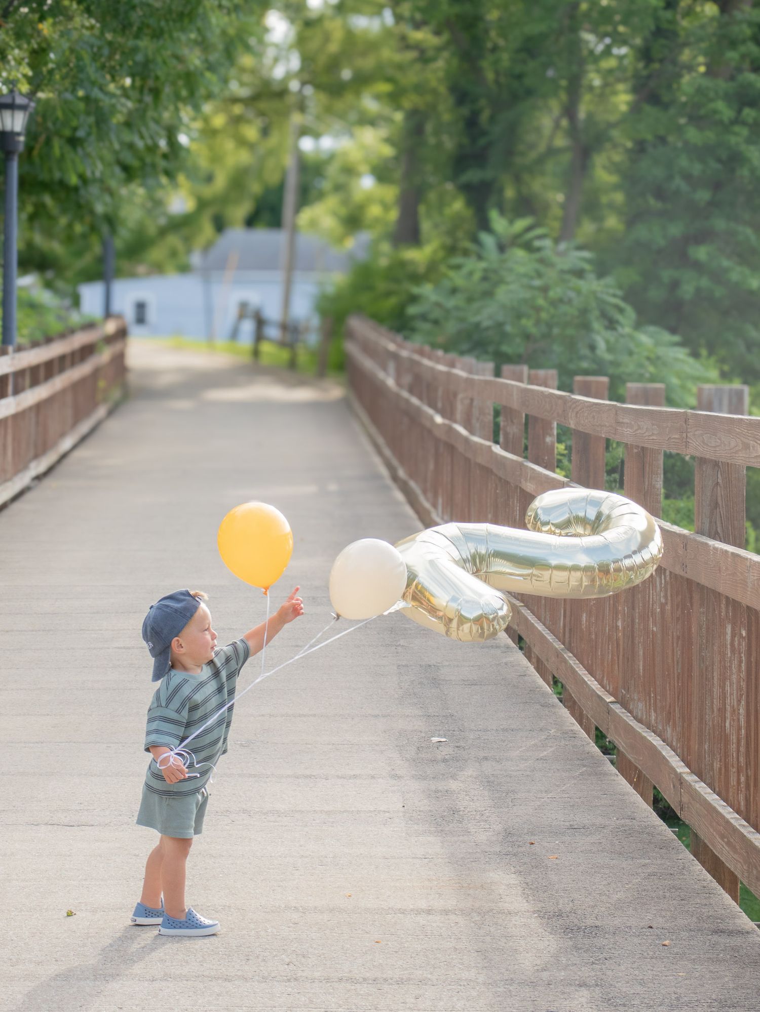 Two year old boy playing with  balloons.