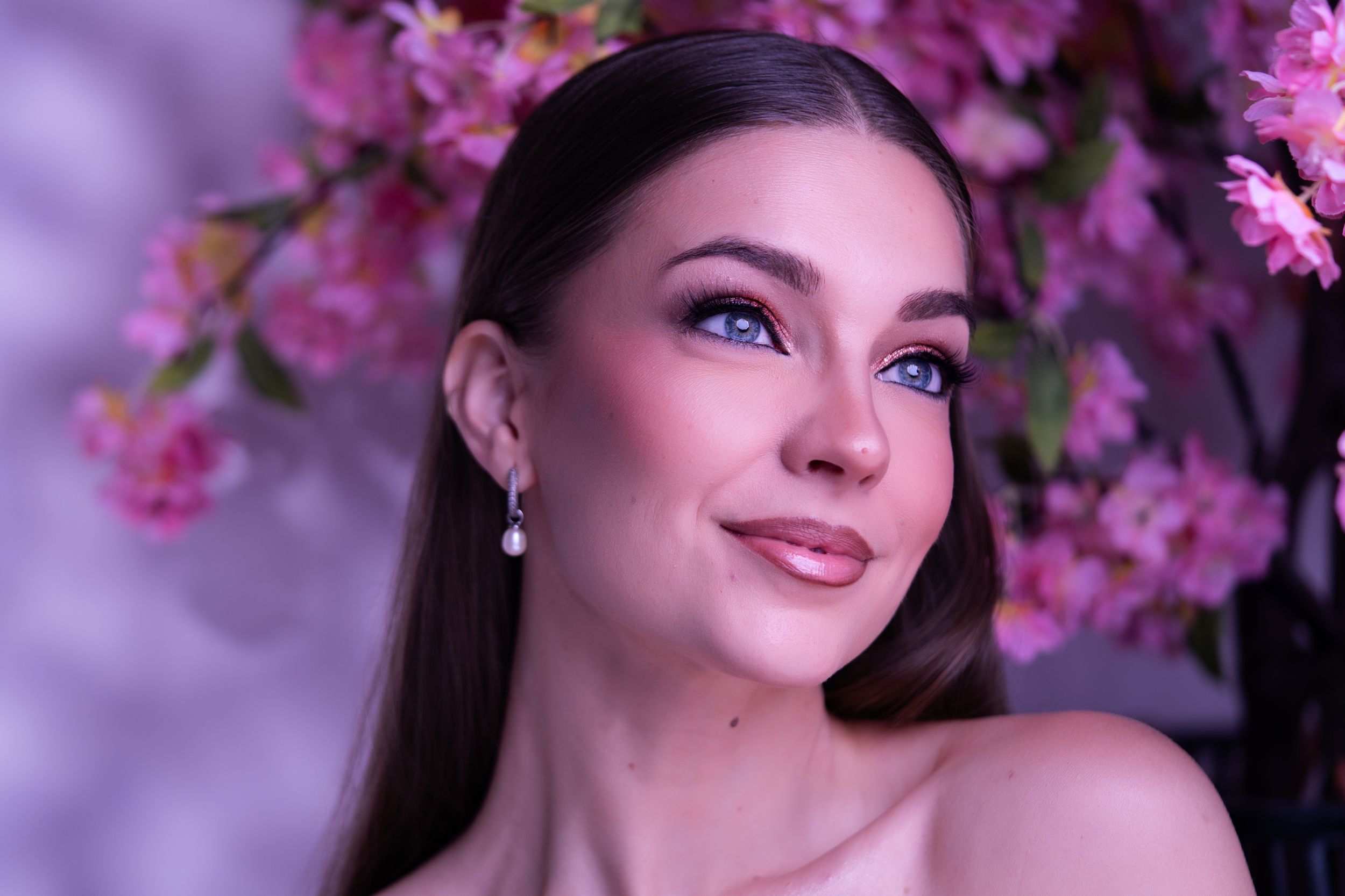 Beauty portrait featuring radiant skin, soft glam makeup, and floral-inspired editorial styling