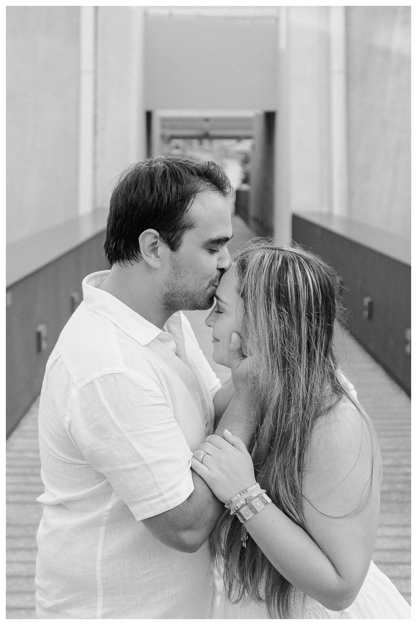 Couple sharing a kiss during a family photo session at Dreams Bahia Mita, celebrating their anniversary by the beach.