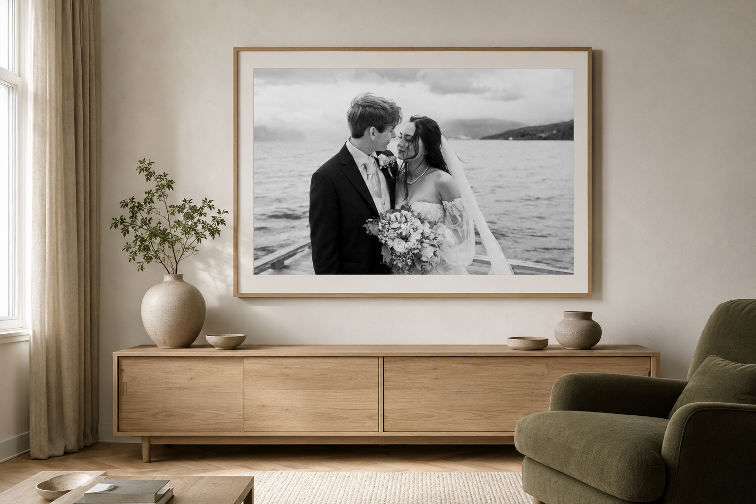 Black and white framed wedding photo of a couple kissing displayed above a wooden sideboard in a modern living room.