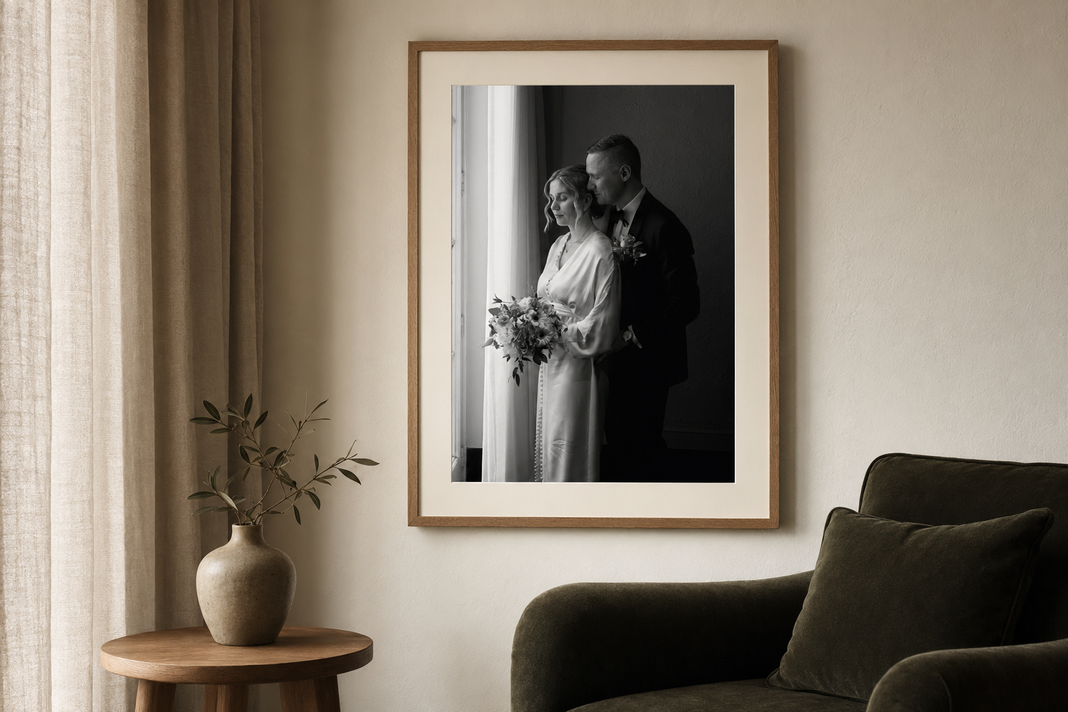 Black and white framed wedding photo of a couple in elegant attire displayed on a neutral wall above a cozy living room.