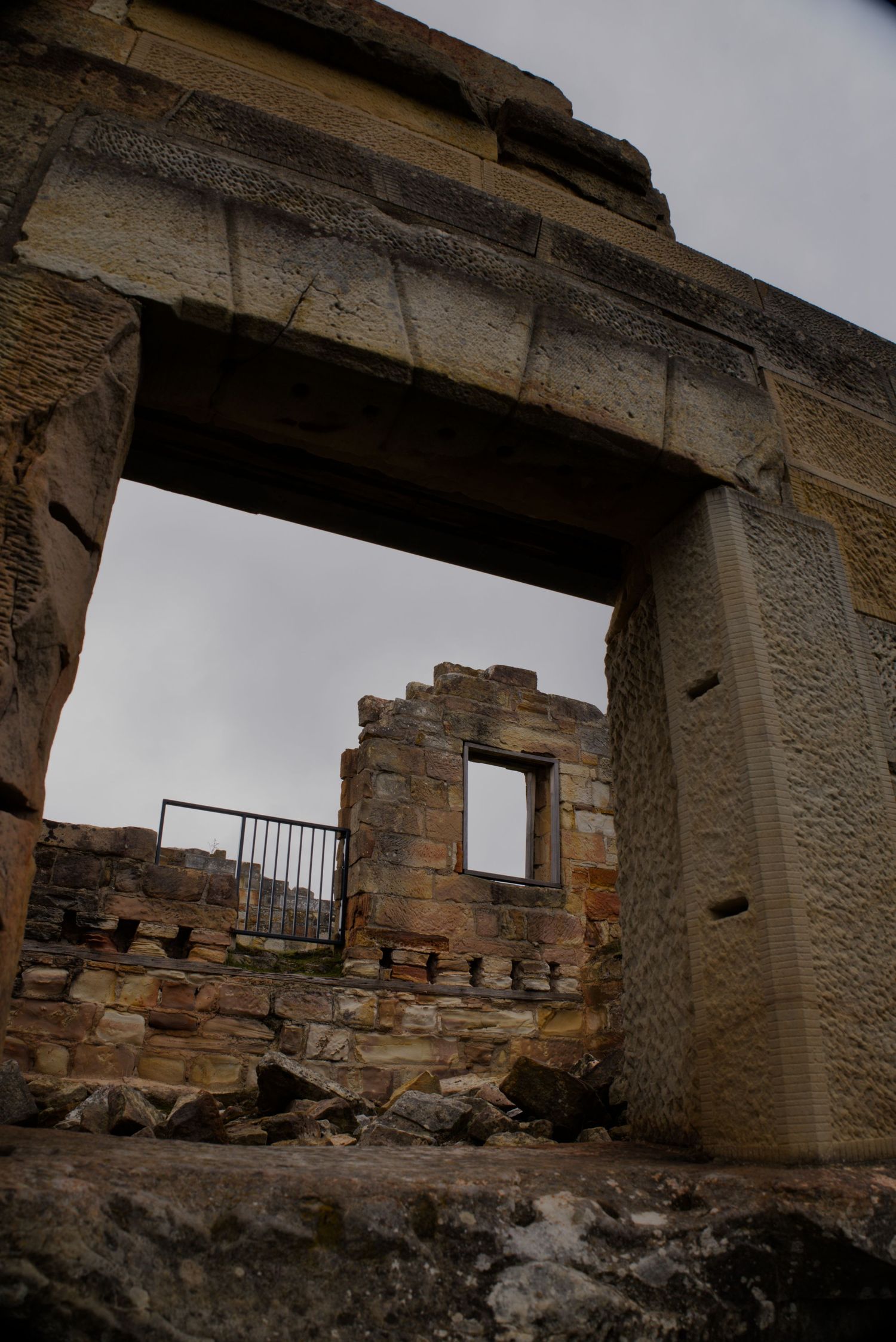 Low-angle view through ancient stone ruins doorway revealing crumbling historic building walls.