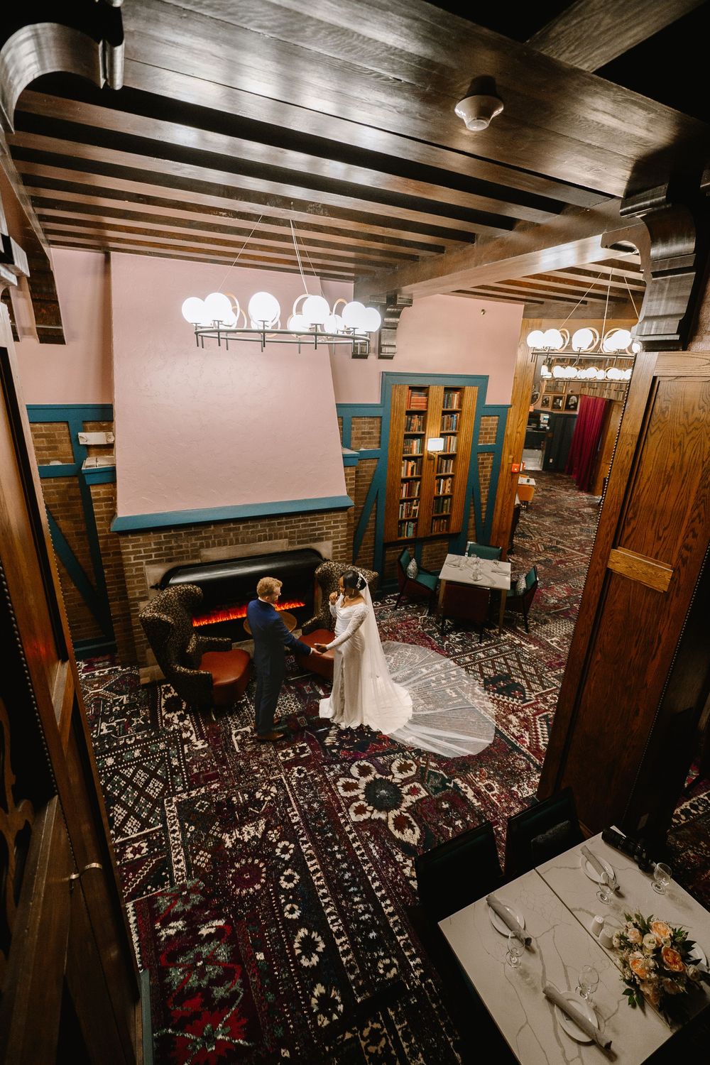 Aerial view of bride and groom sharing a first look in an elegant library venue with ornate rugs.
