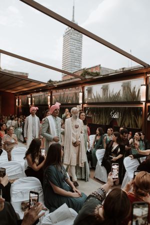 Guests gather under a covered outdoor venue during a wedding celebration.