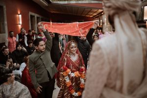 Wedding celebration scene with guests mingling under warm lighting and decorative elements.