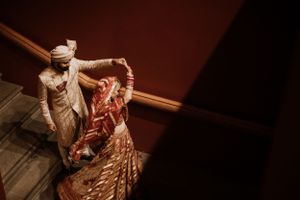 Wedding celebration captured in dramatic low-light conditions with rich red tones.