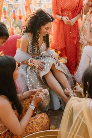 Wedding guests in orange and white outfits celebrating at a festively decorated event.