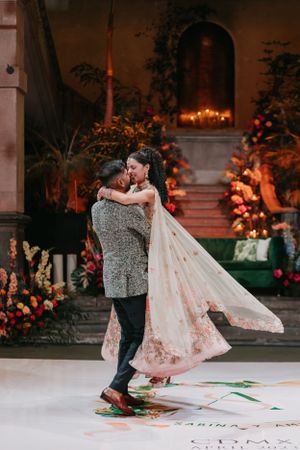Couple dancing together on a decorated outdoor dance floor at night.