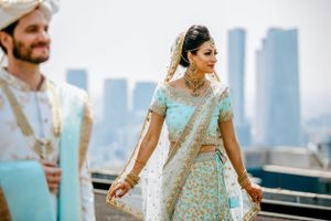 Couple shares joyful moment during wedding celebration with city skyline visible in background.