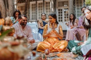 Wedding guests gather around a table enjoying a traditional Indian celebration meal.