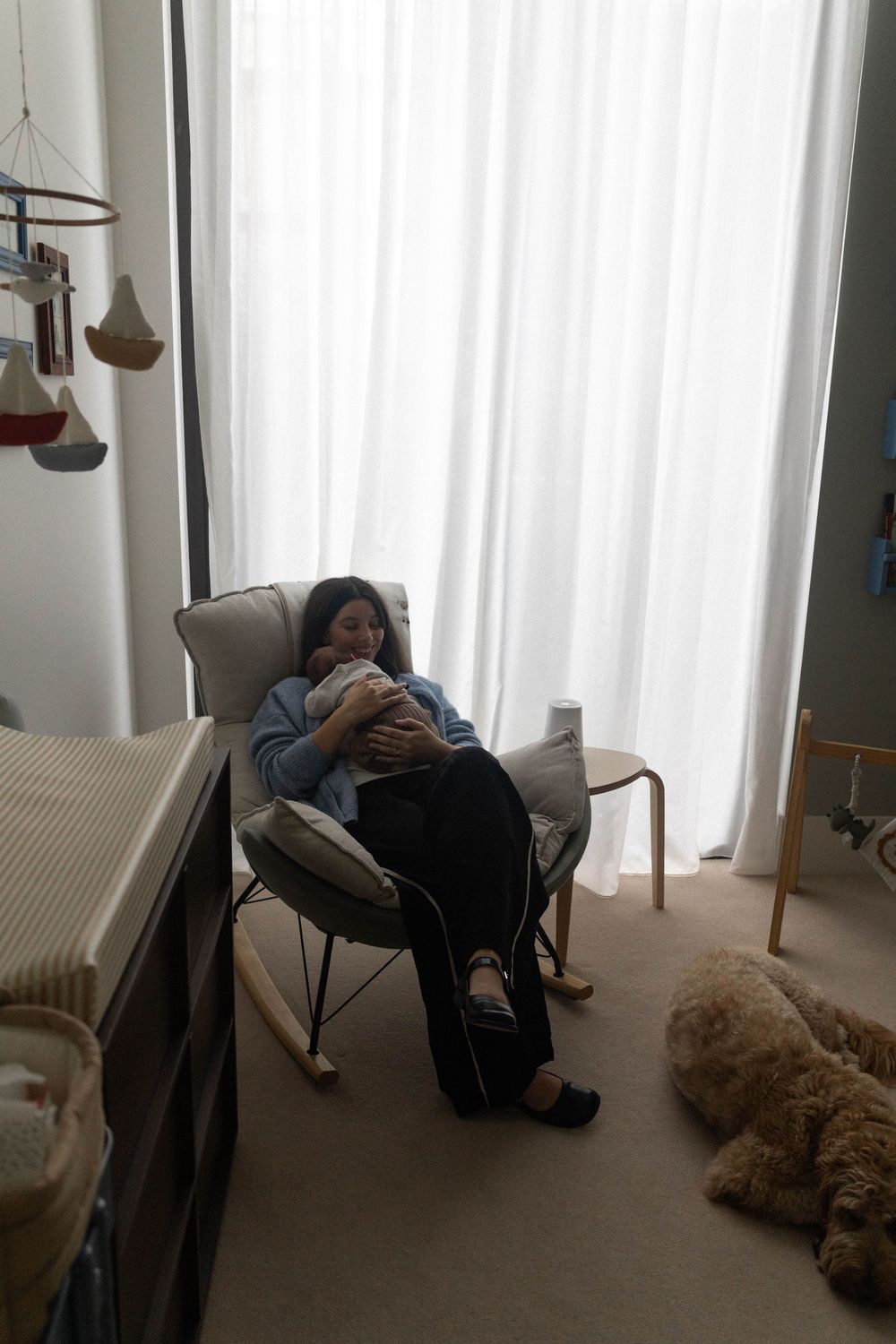 Mother holding newborn in her cozy nursery