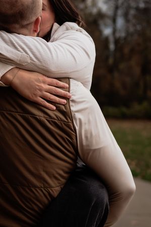 Close-up of couple embracing and kissing in an outdoor autumn setting.