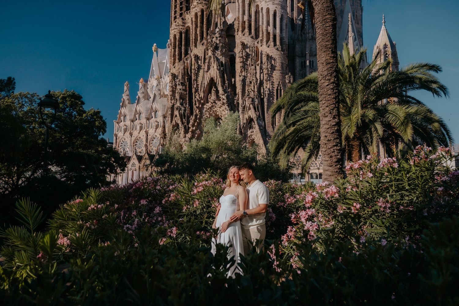 Candid couple laughing on a quiet side street near Sagrada Familia during an early morning photoshoot in Barcelona.
