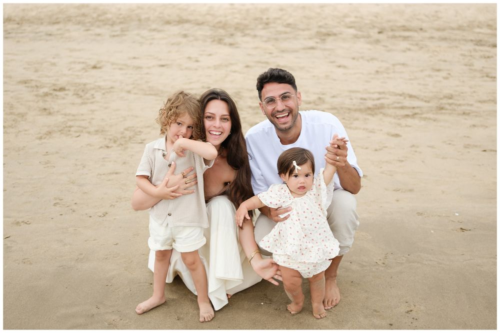 Family sitting together on the beach during a  portrait session in Riviera Nayarit.