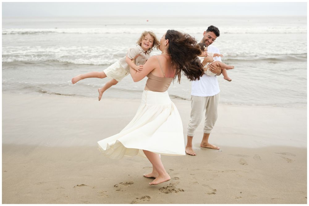 Parents and children laughing together on a resort boardwalk at Grand Velas Riviera Nayarit.