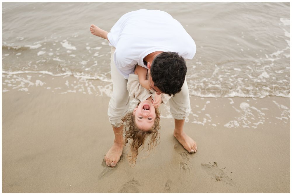 Father playing upside down with his daughter on the sand during a Punta Mita family photography session.