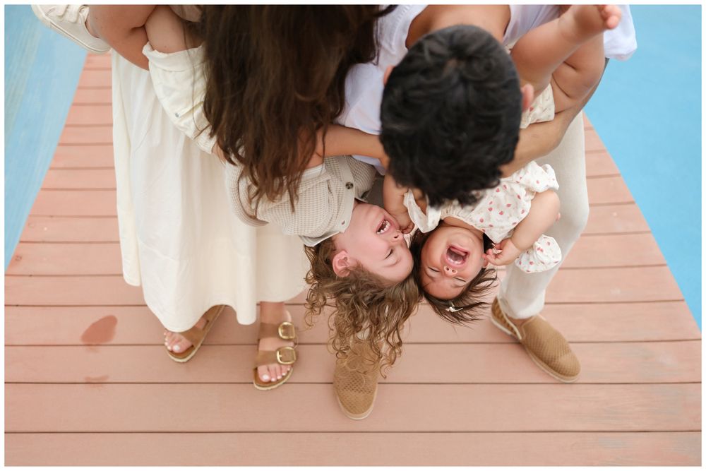 Parents and children laughing together on a resort boardwalk at Grand Velas Riviera Nayarit.