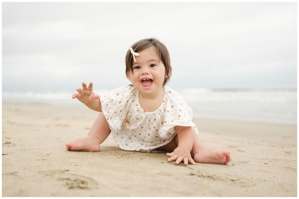 Baby sitting on the sand during a family beach photo session at Grand Velas Riviera Nayarit.